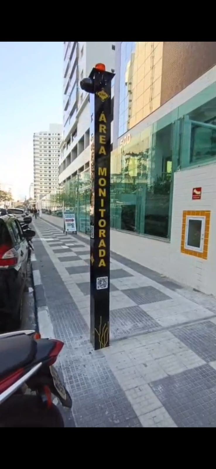 Torre de monitoramento XGUARDIAN instalada diante de edifício na avenida