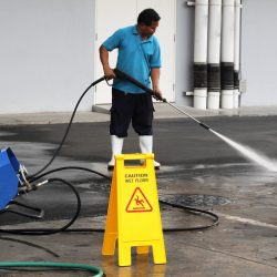 worker cleaning floor with air high pressure machine